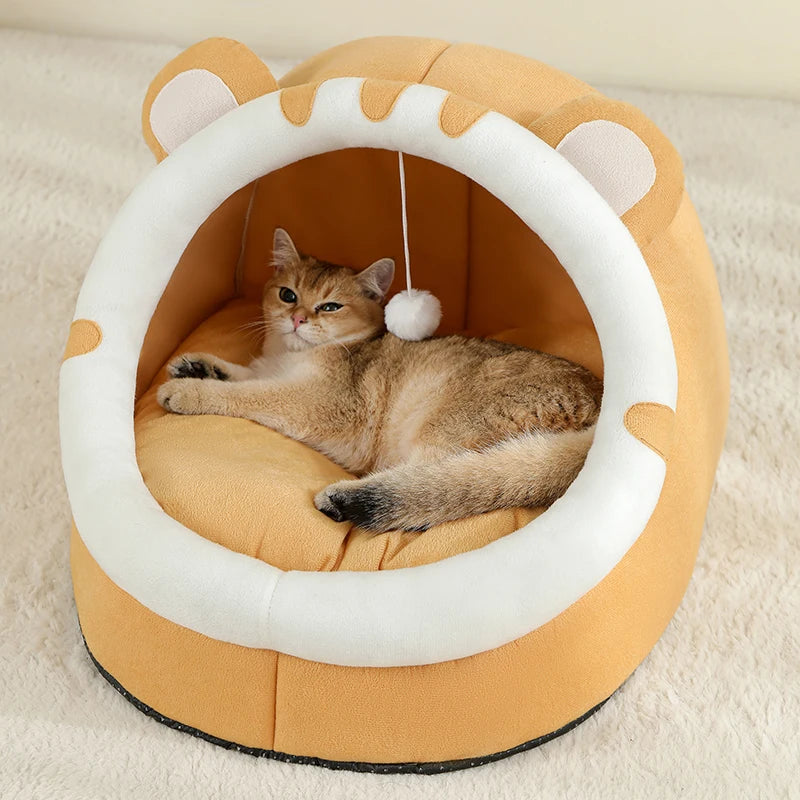 Cat lying on a round, beige pet bed with white rim and cat ears.

